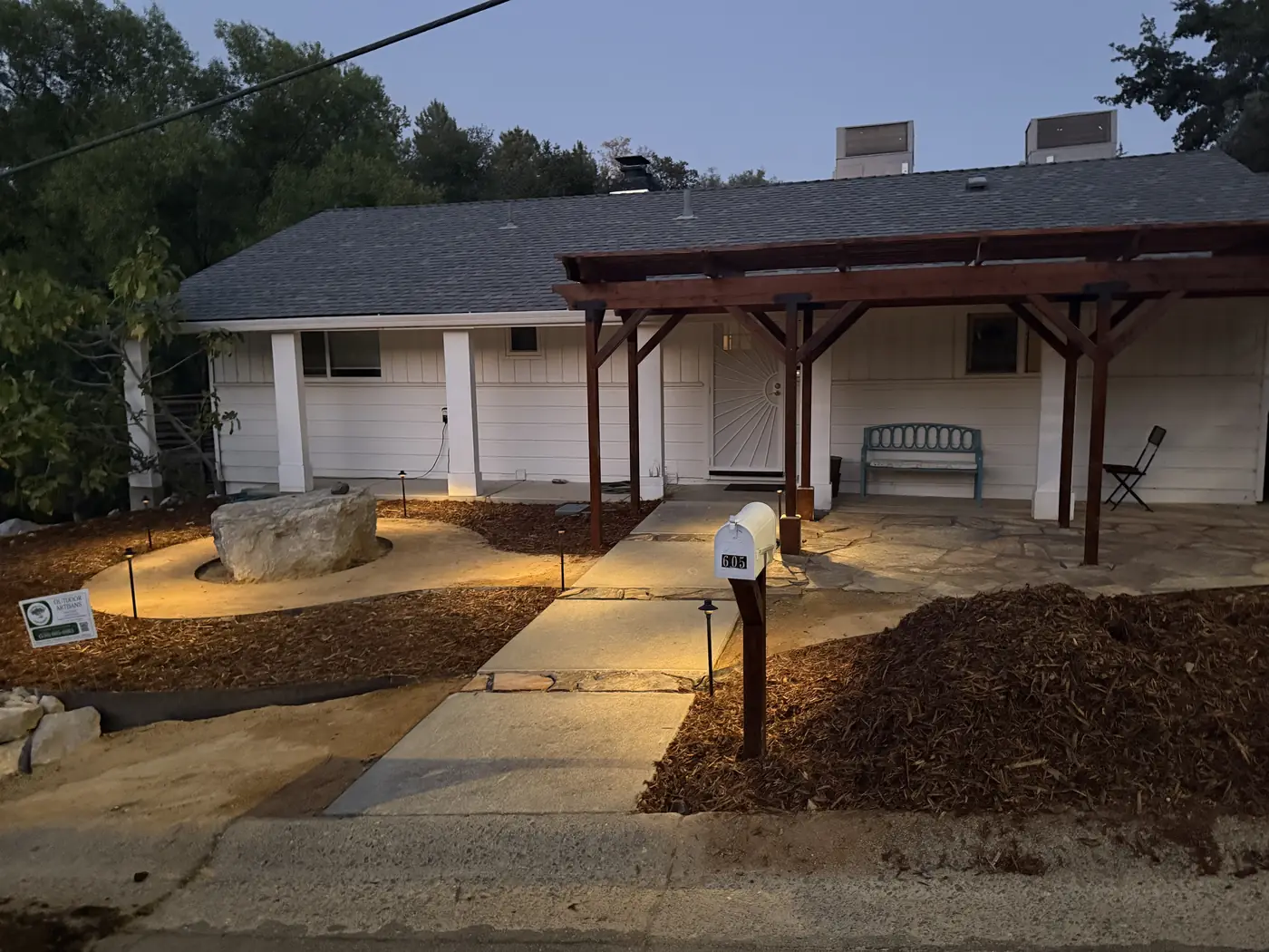 Front walkway and pergola with landscape lighting at dusk