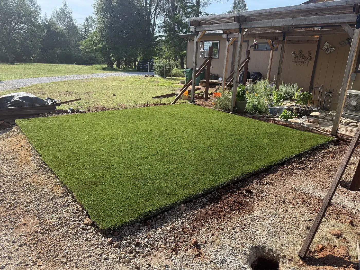 Artificial turf lawn edged in gravel beside a house