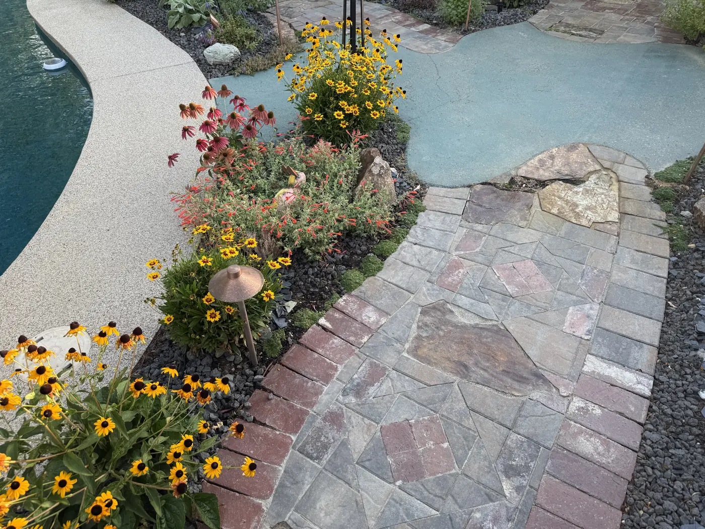 Brick and flagstone walkway through a flowering garden